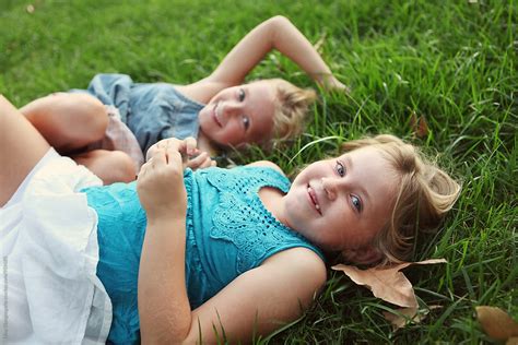 Sisters Laying In Grass Laughing By Stocksy Contributor Dina Marie Giangregorio Stocksy
