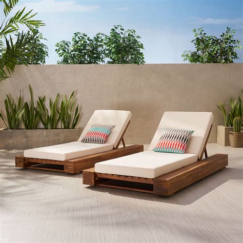 Invite your favorite person to relax in style on this dual chaise lounger for porch, patio, or yard. Rigby Outdoor Acacia Wood Chaise Lounge and Cushion Sets ...