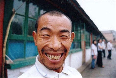 A Smiling Man With His Mouth Open In Front Of A Group Of People On The Sidewalk