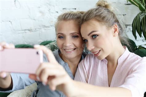 Portrait Of Beautiful Mature Mother And Her Daughter Making A Selfie
