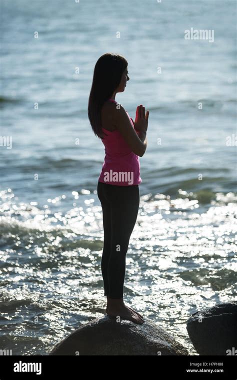 Beautiful Woman Meditating On Rock Stock Photo Alamy