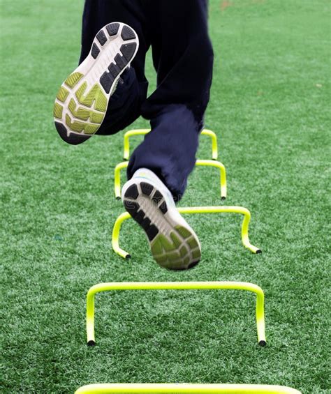Athlete Jumping Over Small Yellow Hurdles On One Leg Close Up Stock