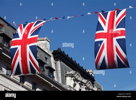 Two British Union Jack National Flags Flying Against Blue Sky