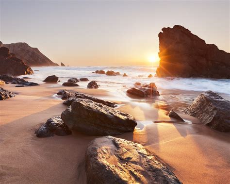 Sunrise On The Beach Rocks Sand Sea