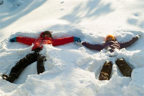 Premium Photo Two People A Man And A Woman Make Snow Angels In A Deep