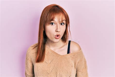 Redhead Young Woman Wearing Casual Winter Sweater Scared And Amazed