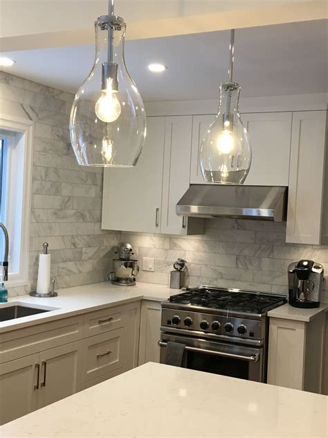 A Kitchen With Two Lights Hanging From The Ceiling