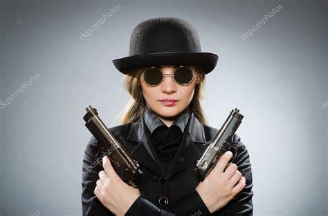 Female Spy With Weapon Against Gray Stock Photo By ©elnur 86569624