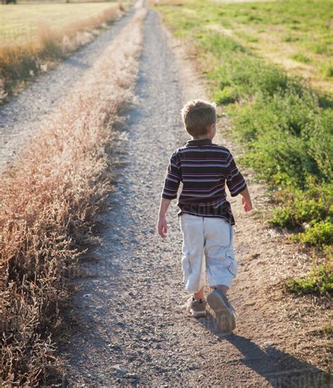 Young Boy Walking On Rural Path Stock Photo Dissolve
