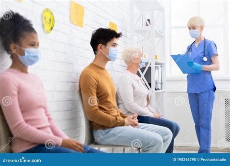 Diverse People Sitting Waiting For Doctor`s Appointment In Hospital