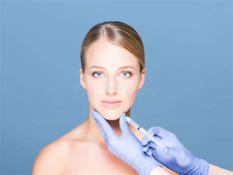 Young And Beautiful Woman Having Skin Injections Over Cyan Background Plastic Surgery Concept