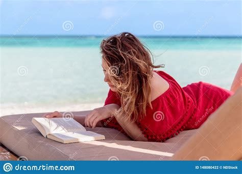 Woman On A Sunchair Reading A Book In A Tropical Location Clear
