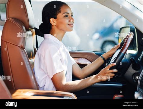 Confident young woman driving car. Side view of female holding a