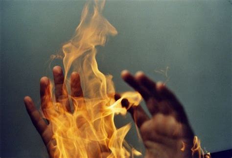 Two Hands Reaching Out Towards Fire With Their Fingers