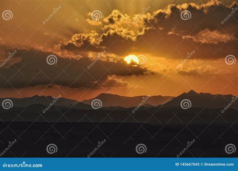 Sunset Over The Mountains With Sun Shining Through The Clouds Editorial
