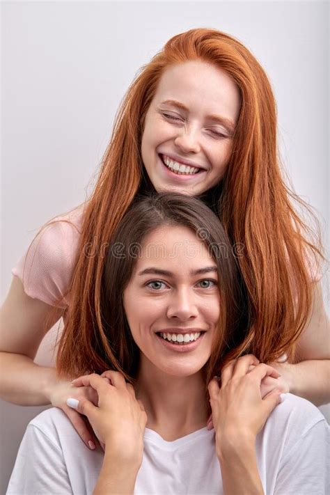 two diverse women lesbian couple hugging looking at camera close up