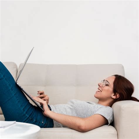 Seitenansicht Der Frau Auf Der Couch L Chelnd Beim Arbeiten Am Laptop