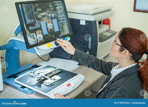 Woman Examines Microcircuits On A Special Apparatus For Reading The