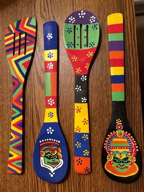 Three Spoons And Two Forks Painted With Colorful Designs On Them