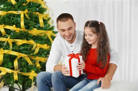 Padre E Hija Abriendo Regalo De Navidad En El Salón Foto Premium