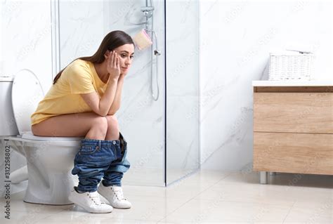 Upset Woman Sitting On Toilet Bowl In Bathroom Stock Photo Adobe Stock