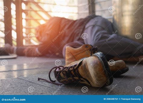 Old Shoes And Homeless Homeless Man Is Lie Down On Walkway In Townhe