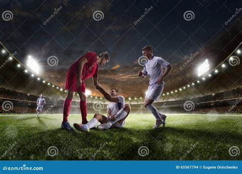 Soccer Player Helps Onother One Sunset Stadium Background Panorama