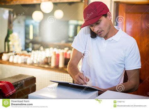 Pizza Delivery Man Taking An Order Over The Phone Stock Photo Image