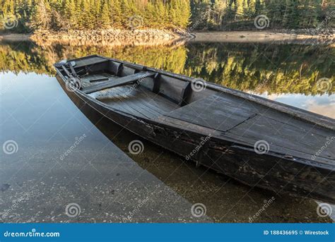 Wooden Boat On The Coast Of The Lake And The Forest In The Background