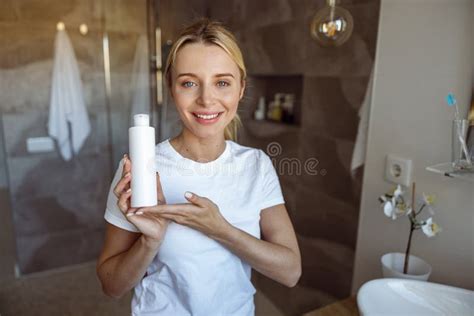 Portrait Of Pretty Young Blonde Woman Showing Skin Moisturizer In