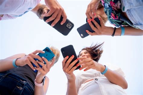 Groupe De Jeunes Amis Utilisant Un Téléphone Portable Photo Premium