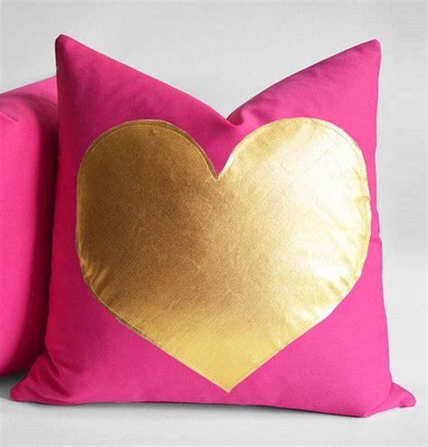 A Pink And Gold Pillow With A Heart On It