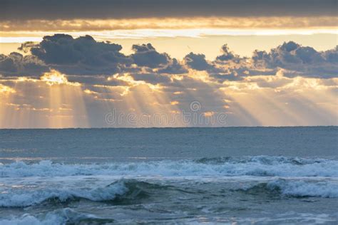 Sky With Sunbeams Radiating Out Under Colorful During A Sunset Stock