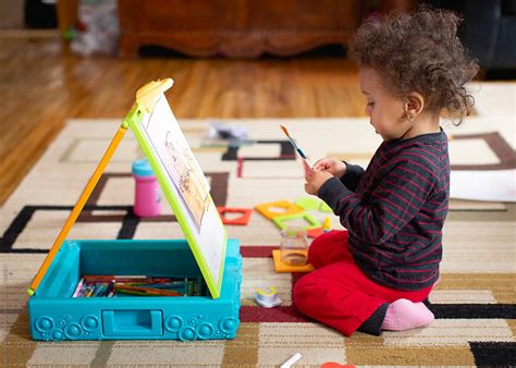 Toddler Child Painting Happily On Her Toy Easel Del Colaborador De