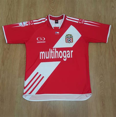 Curicó unido's official kit is a white shirt with a diagonal red stripe that crosses the chest from the right shoulder to the left side of the hip. Curicó Unido Away football shirt 2005.