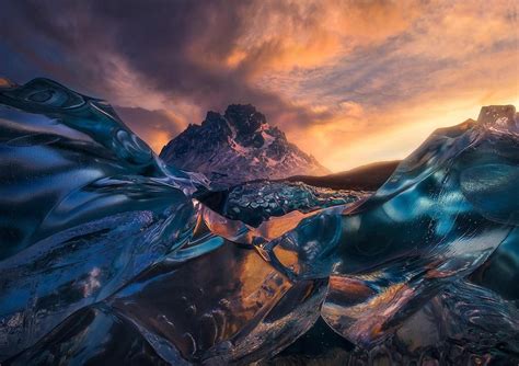 Clear Ice Reflecting A Beautiful Sunrise Under The Peaks At Lago Grey