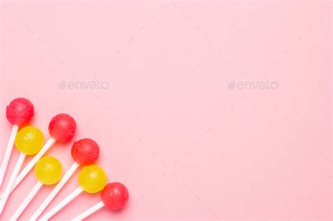 Pastel Pink Background With Sweet Pink And Yellow Candies Lolipop