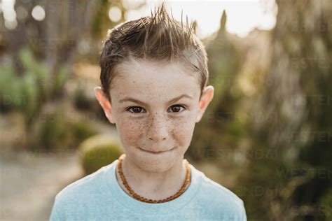 Close Up Portrait Of Cute Young Boy With Freckles Making Serious Face