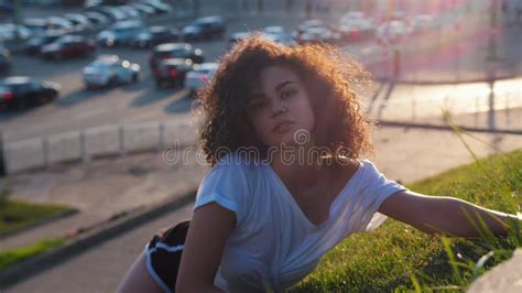 Attractive Skinny Mulatto Woman Lying On The Grass And Performing Strip Dance Elements Flex