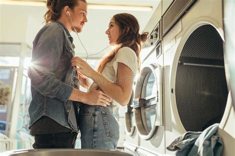 Man Kissing His Girlfriend On Forehead Standing In A Laundry Roo Stock Image Image Of