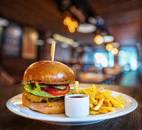 Fresh Tasty Burger And French Fries On Wooden Table Stock Image