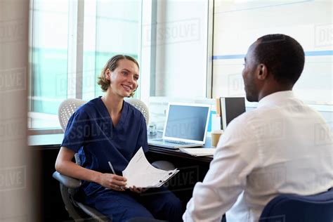Doctor In Consultation With Male Patient In Office Stock Photo Dissolve