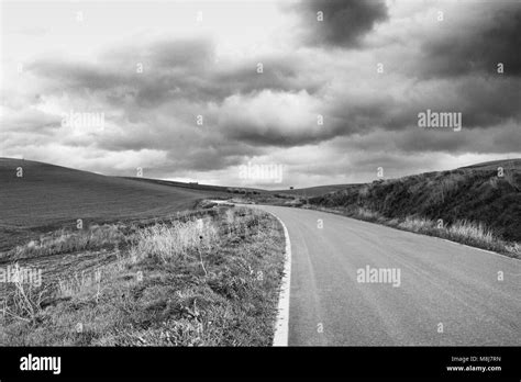 Lonely Art Nature Hills Green Field And Asphalt Road Under Cloudy Sky