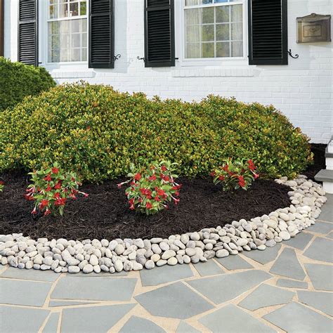 The natural stone creates a beautiful border, which also acts as a retaining wall. Rock Landscaping Ideas That Increase Curb Appeal - The ...