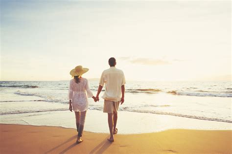 Mature Couple Walking On The Beach At Sunset Wheaton