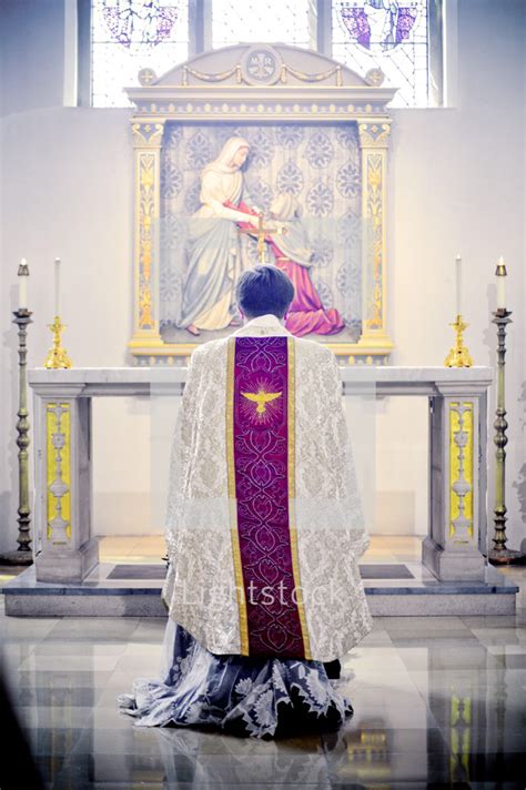 Priest Kneeling In Prayer In Front Of An Altar — Photo — Lightstock