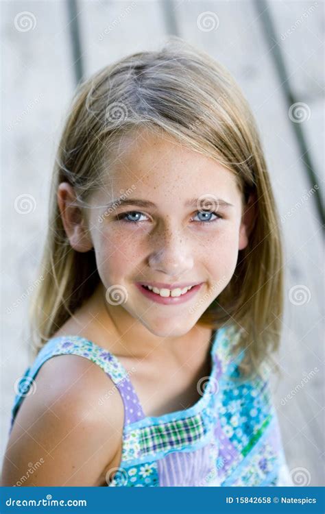 Young Tween Girl Sitting On A Pier Stock Photo