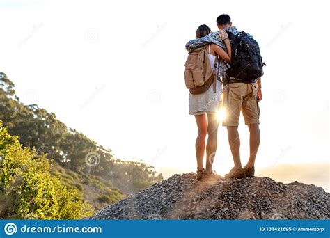 Rear View Of Hiking Couple With Backpack Standing Together On Hill Top