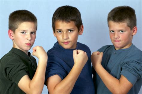 Three Young Brothers Flexing Their Muscles Stock Photo