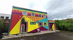 Artist who transforms streets by painting houses different colours has brought her 'rainbow' touch to a school